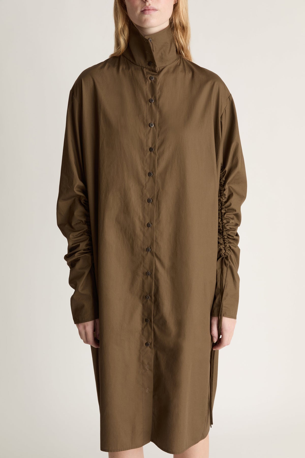 Brown dress worn by a person on a plain background