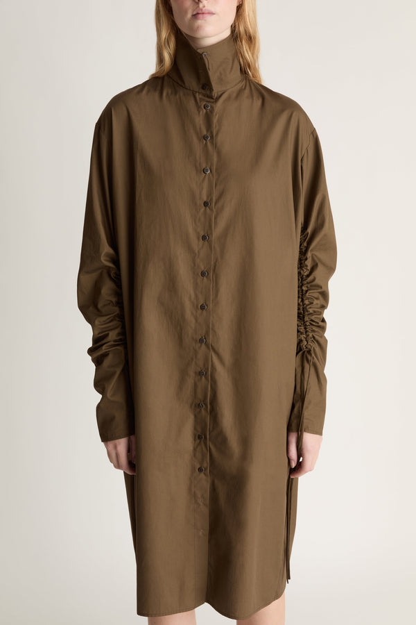 Brown dress worn by a person on a plain background