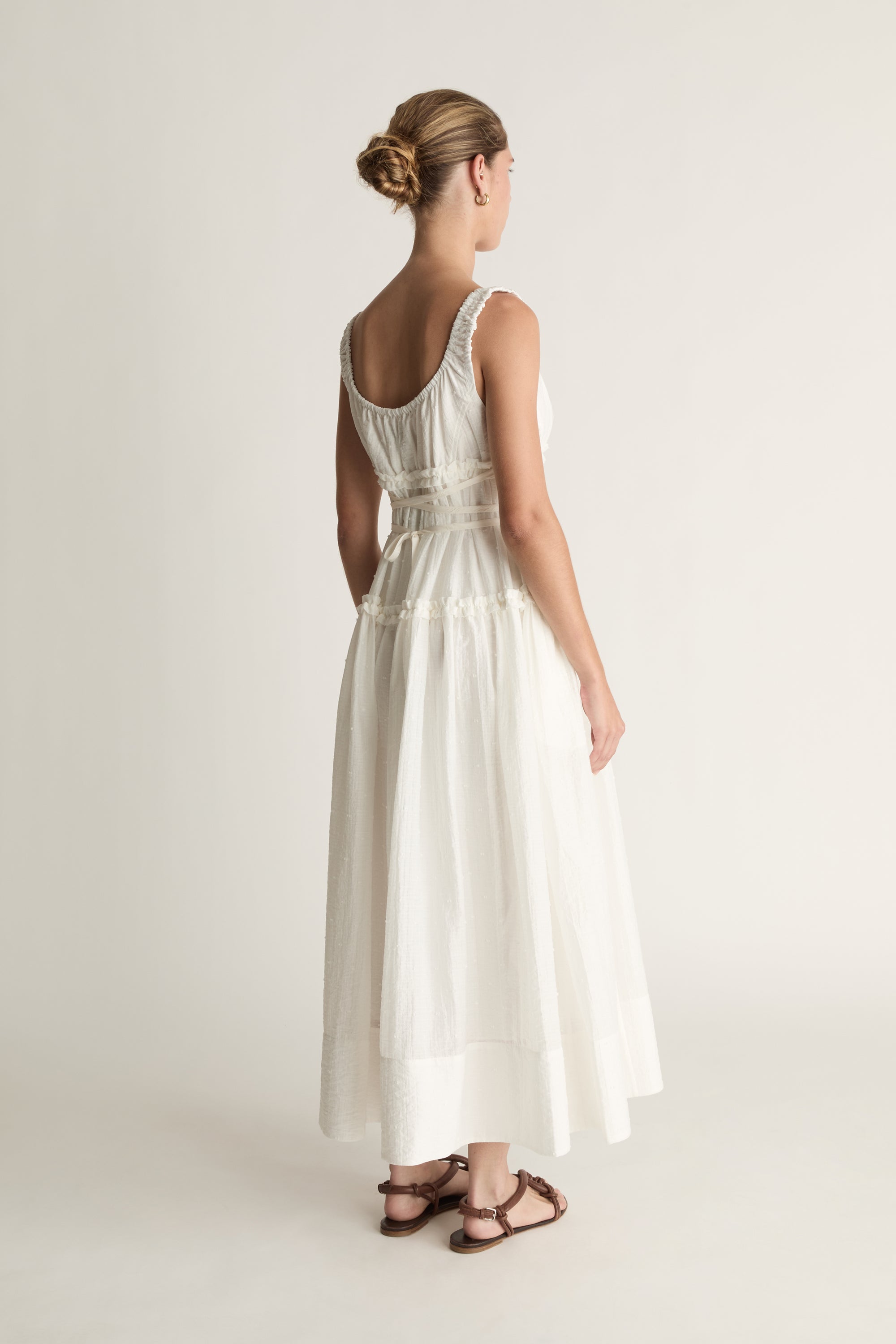 Woman wearing a white dress against a plain background