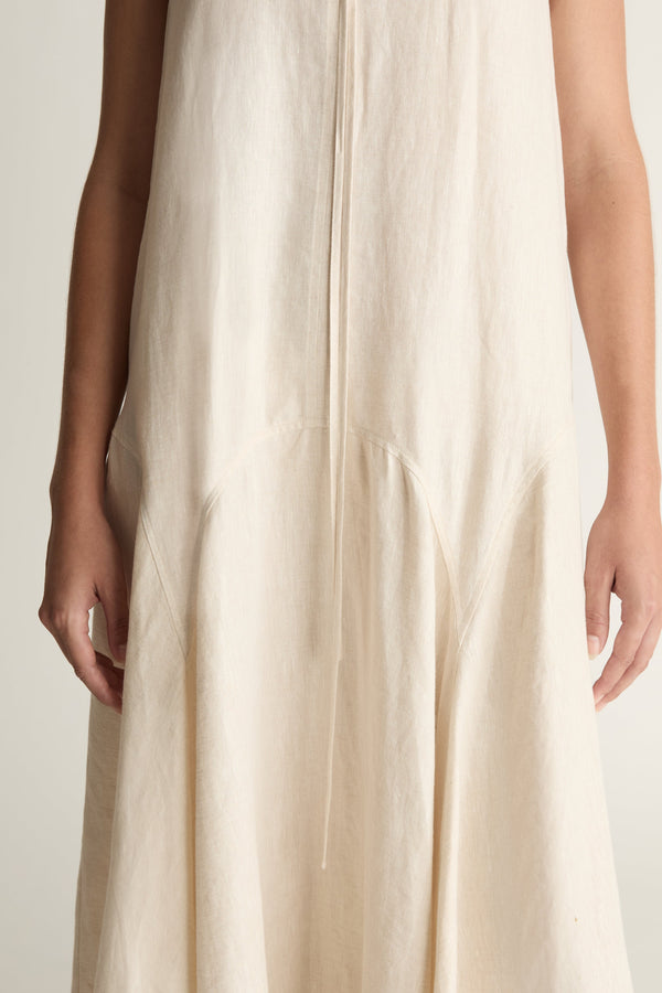 Woman wearing a long beige dress on a white background