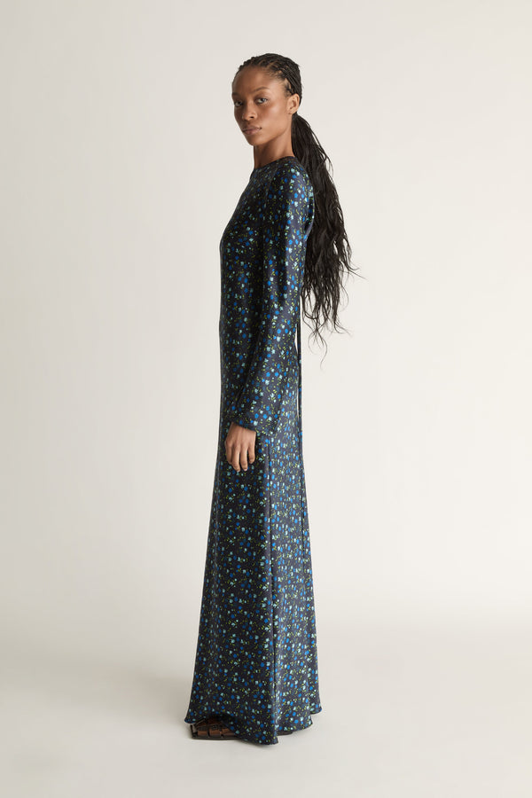 Woman wearing a long-sleeve dress with a pattern on a white background