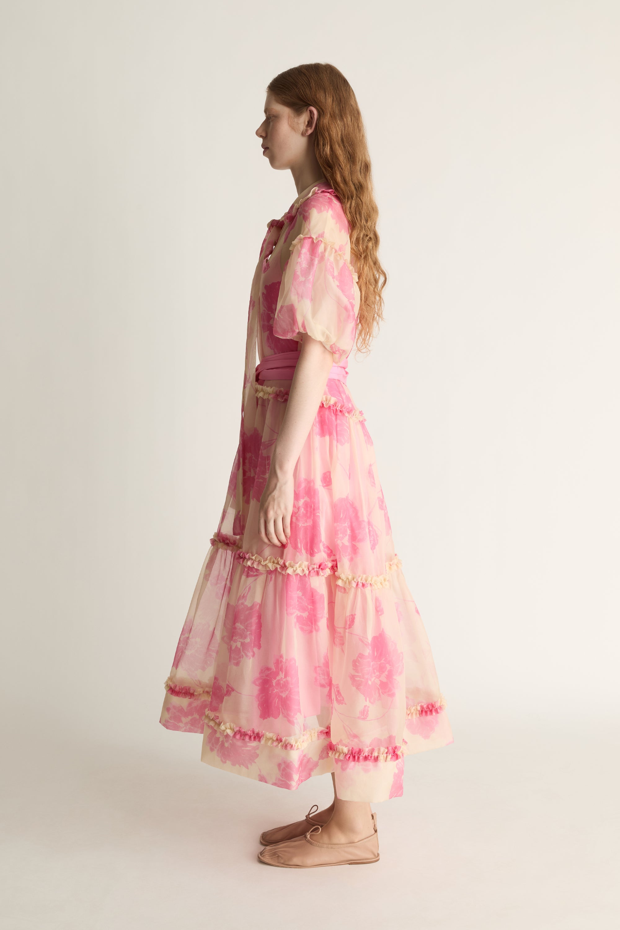 Woman wearing a pink dress with a white background