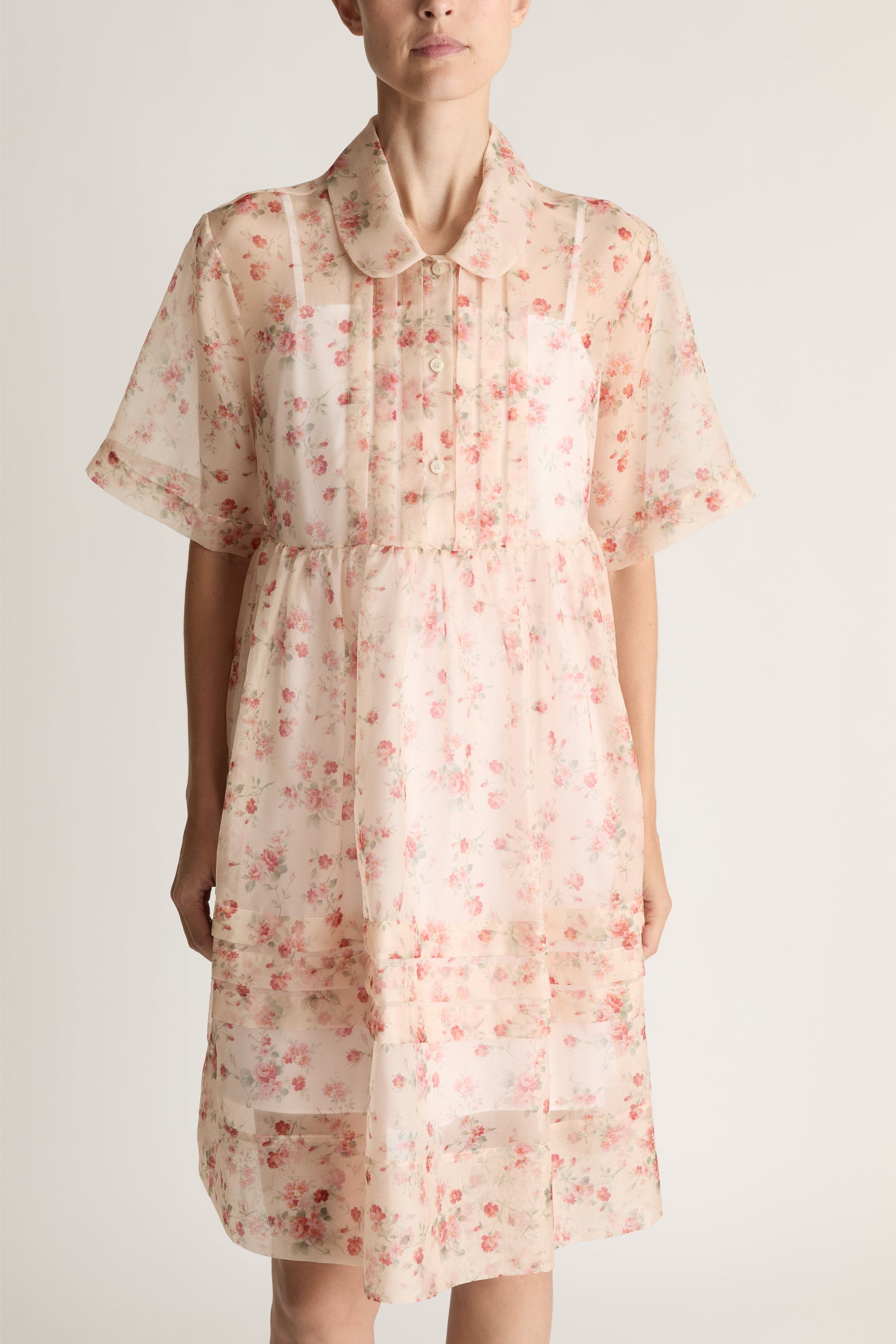 Woman wearing a floral mini dress on a white background