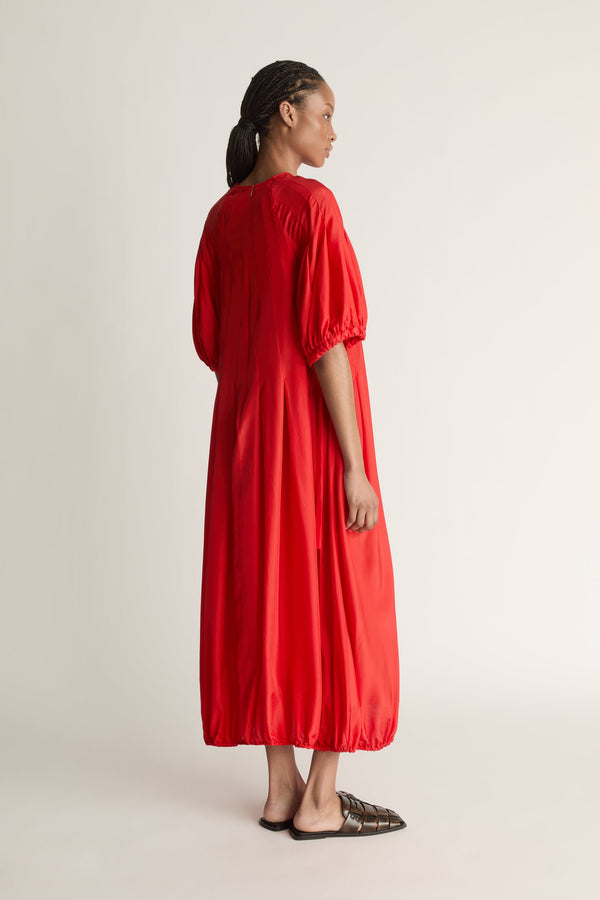 Person wearing a red dress on a white background