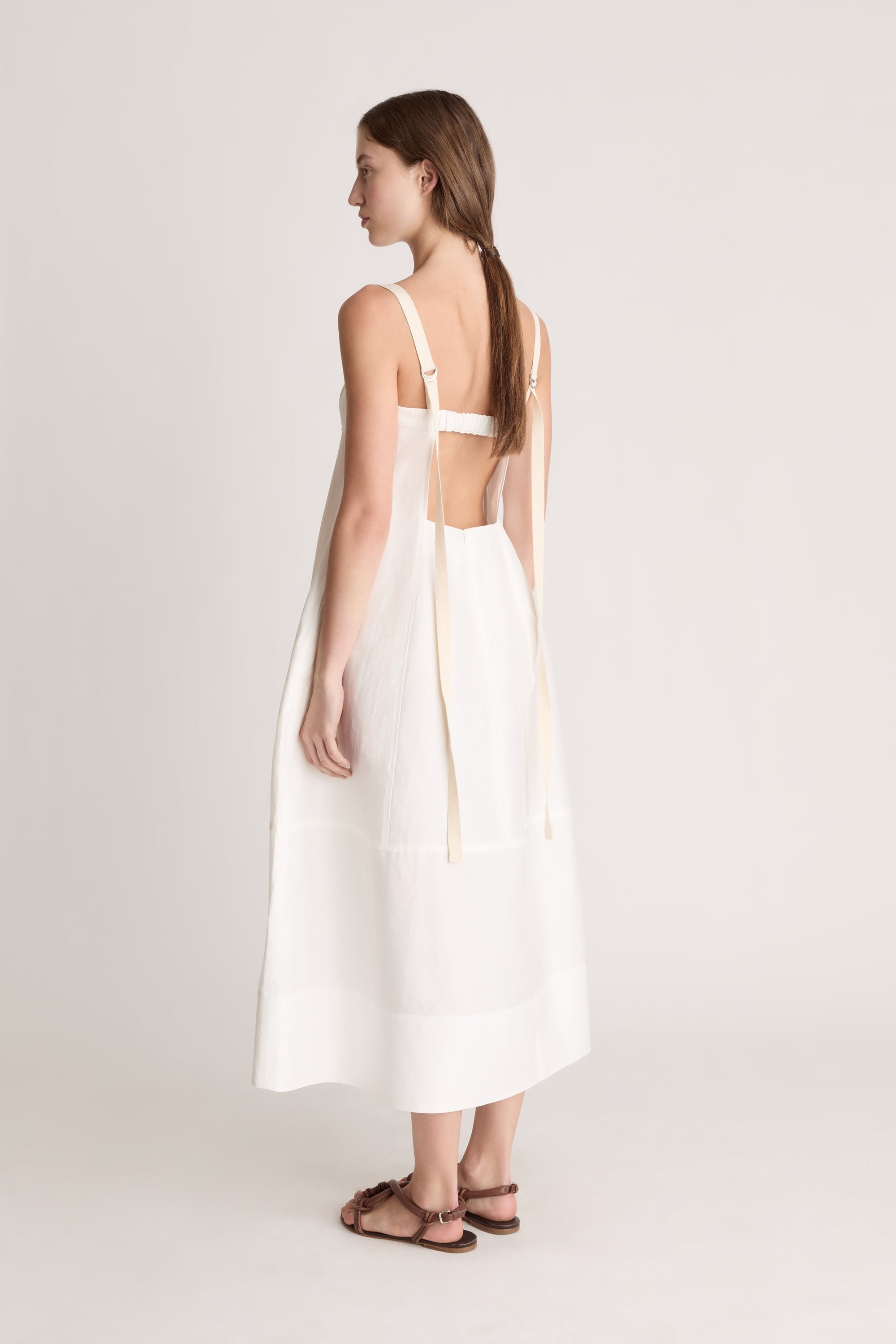 Woman wearing a white dress on a plain background