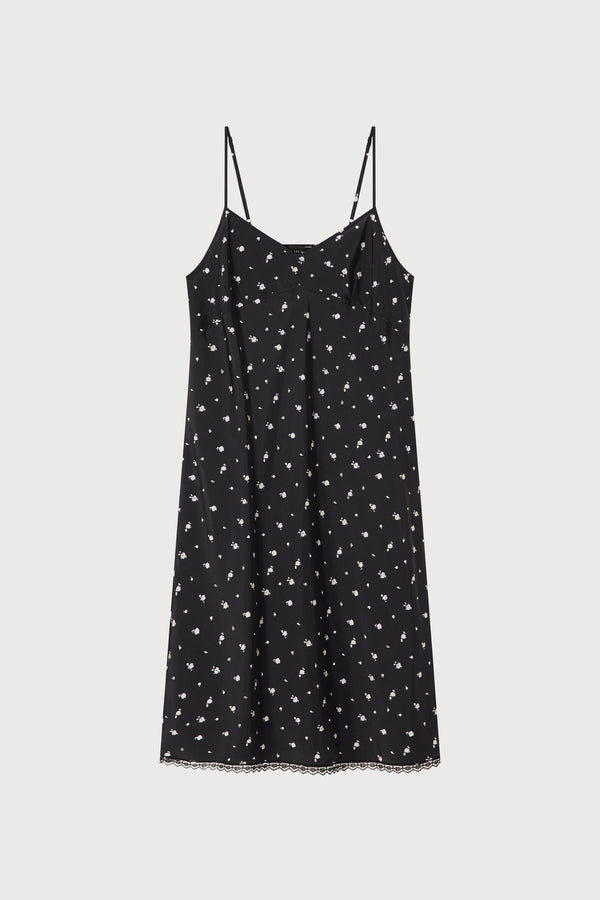 Black slip dress with white floral pattern on a light gray background